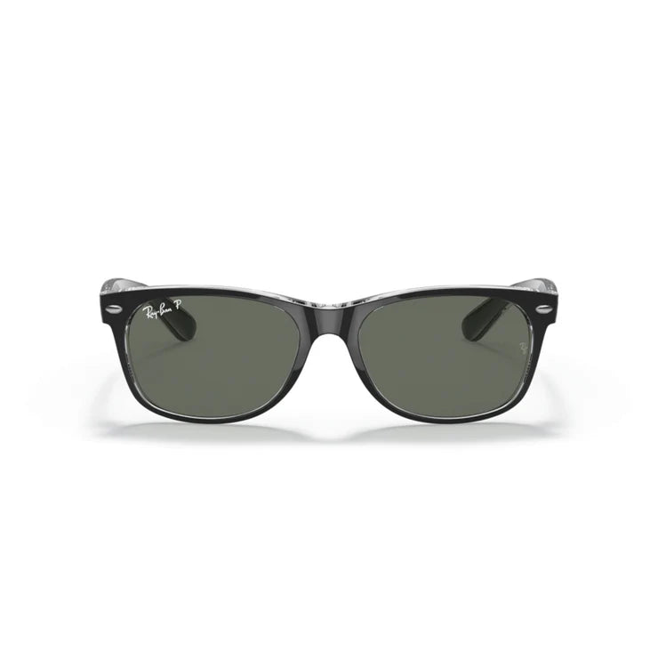 Sunglasses with a black frame and green lenses on a white background