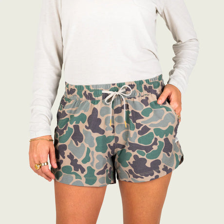 Camouflage shorts worn by a person on a plain background