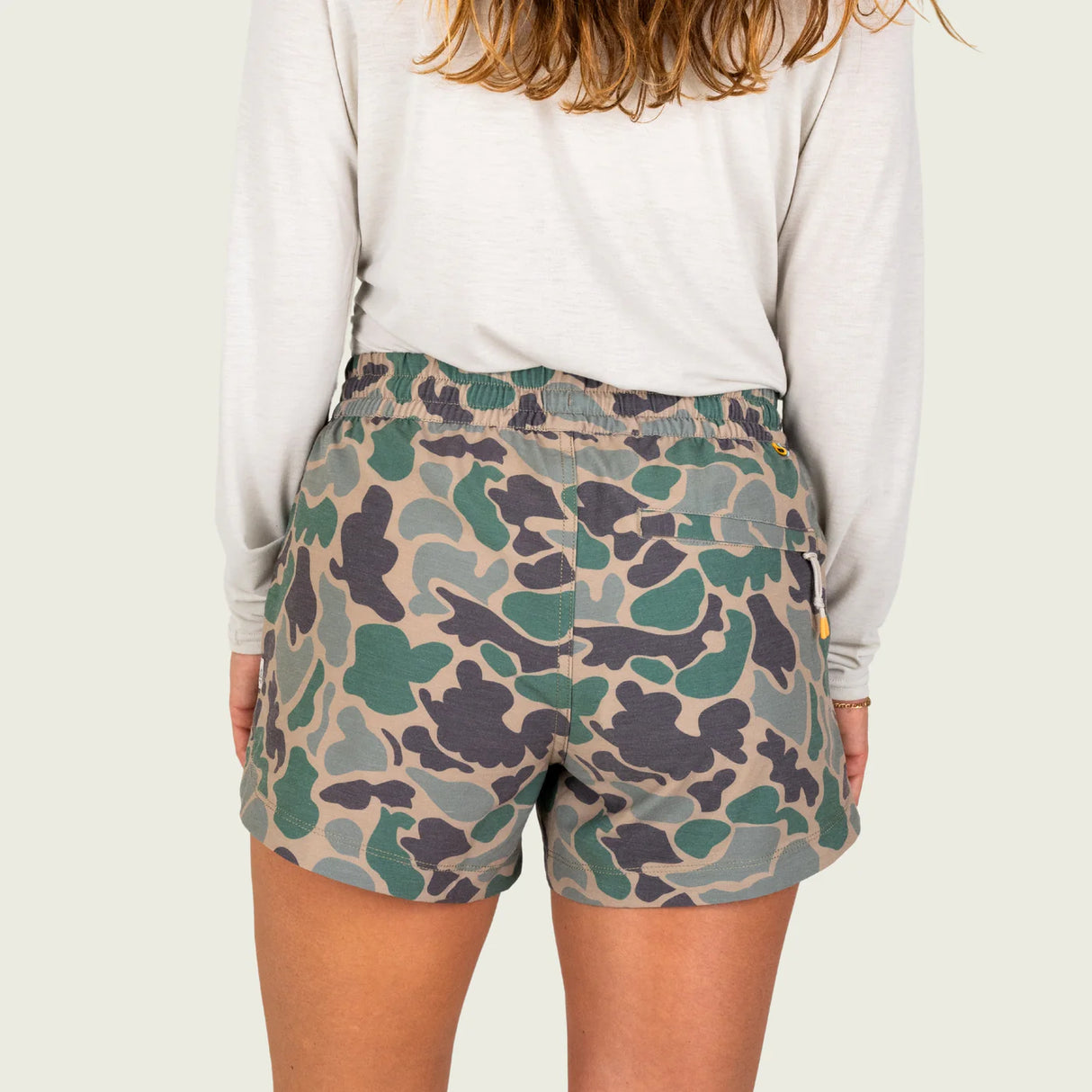 Camouflage shorts worn by a person on a plain background