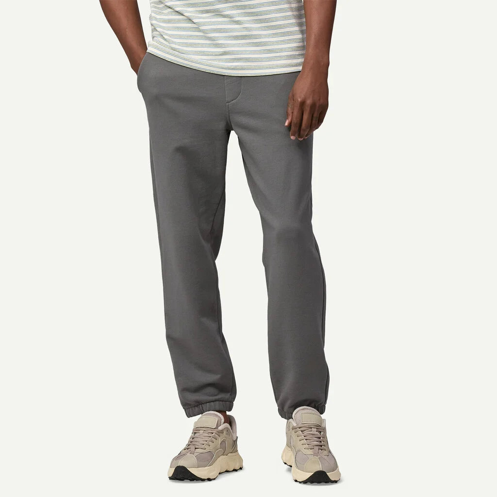 Person wearing gray pants and beige sneakers on a white background