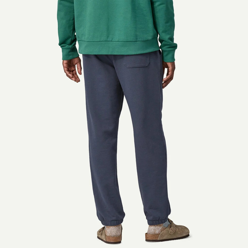 Person wearing a green sweatshirt and blue pants on a white background