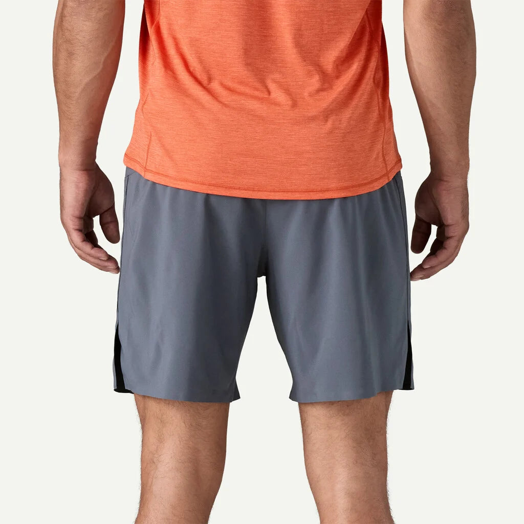Person wearing gray athletic shorts with a black stripe on a white background