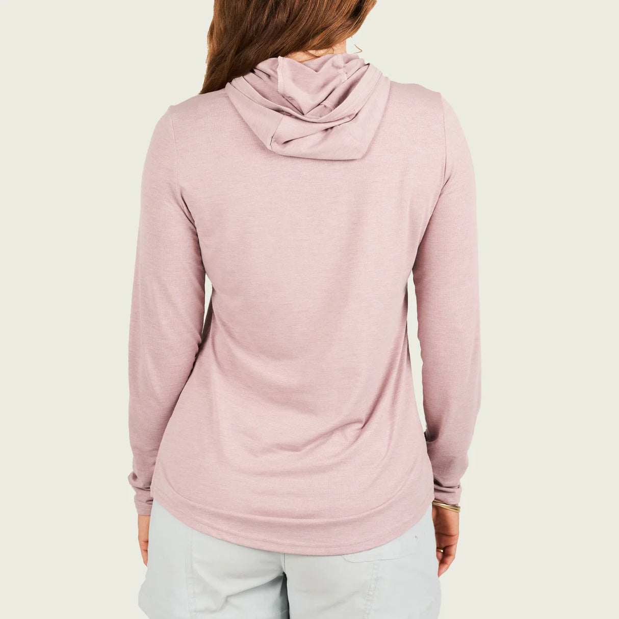 Person wearing a pink hoodie on a plain background
