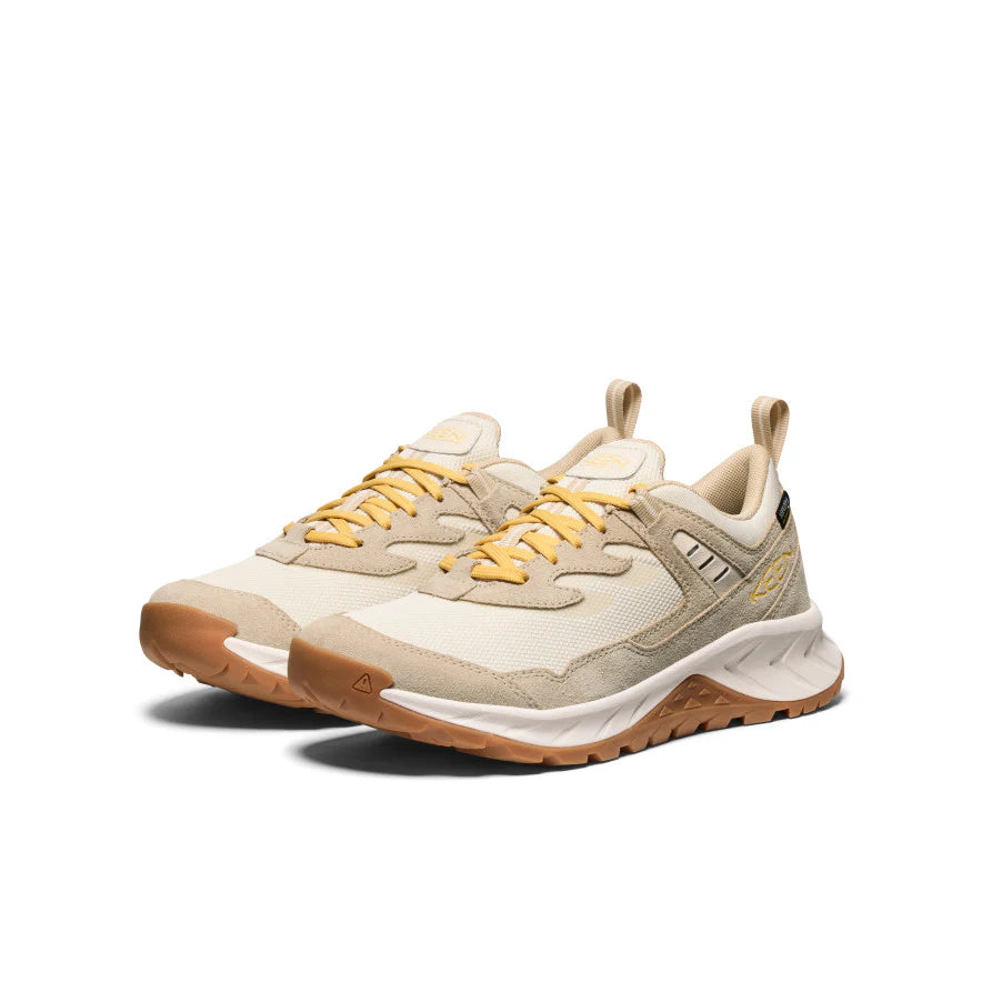 Beige and brown sneakers with yellow laces on a white background