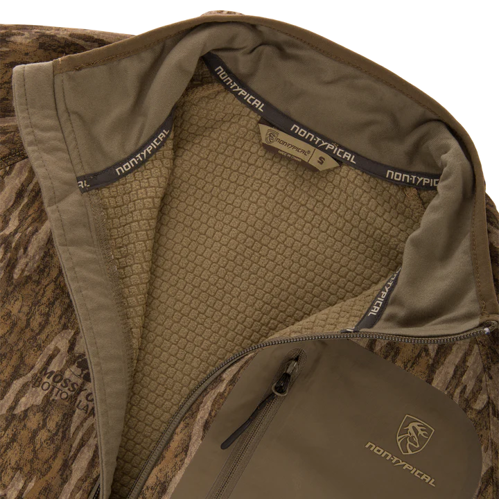 Close-up of a brown jacket with 'Nontypical' branding on a camouflage background