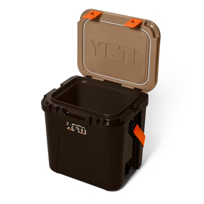 Black YETI cooler with open brown lid on a white background