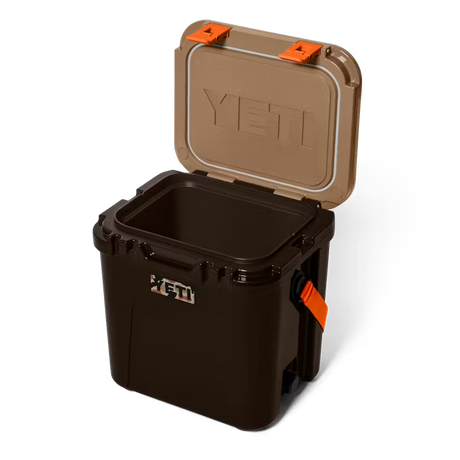 Black YETI cooler with open brown lid on a white background
