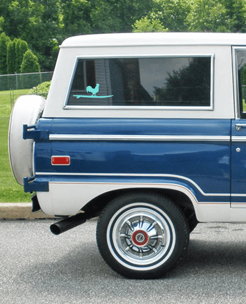 Blue and white vintage truck with a rooster decal on the window.