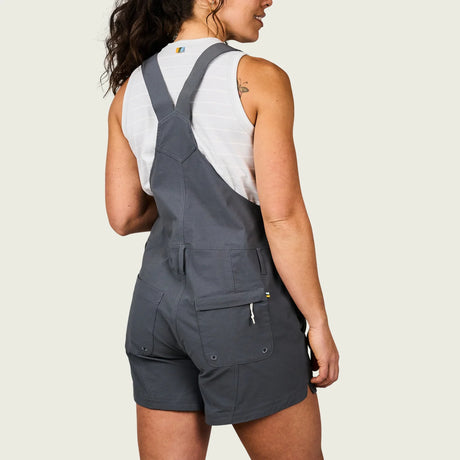 Person wearing gray overalls on a plain background