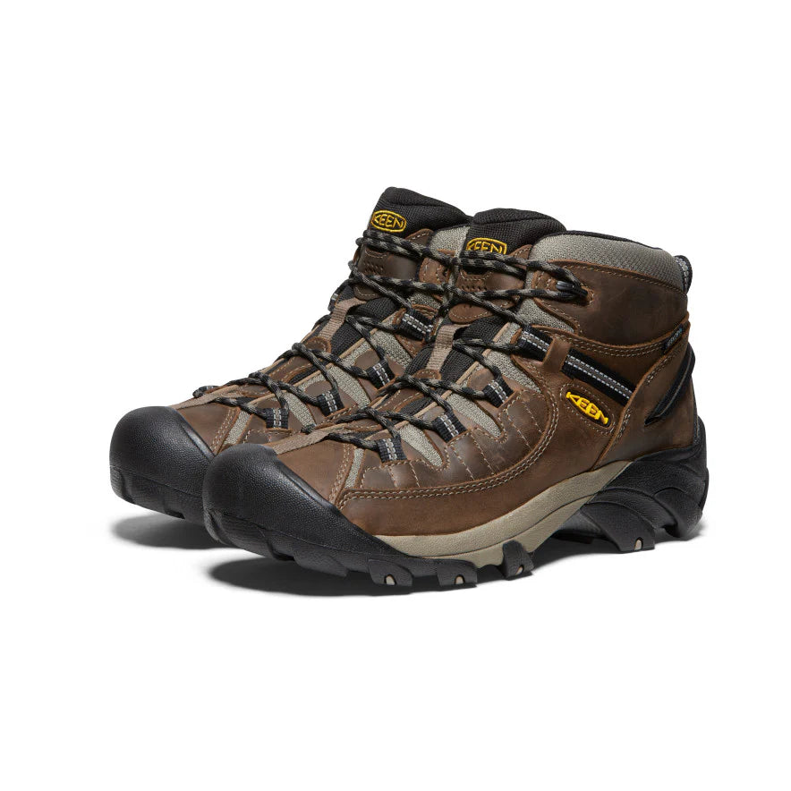 Pair of brown hiking boots with black soles on a white background