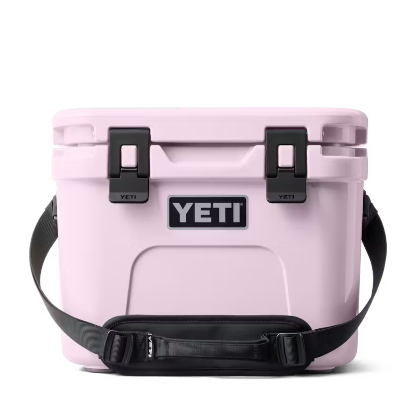 Pink YETI cooler with black straps on a white background