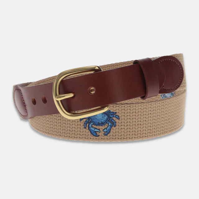 Belt with brown leather strap and embroidered blue crab design on a beige background
