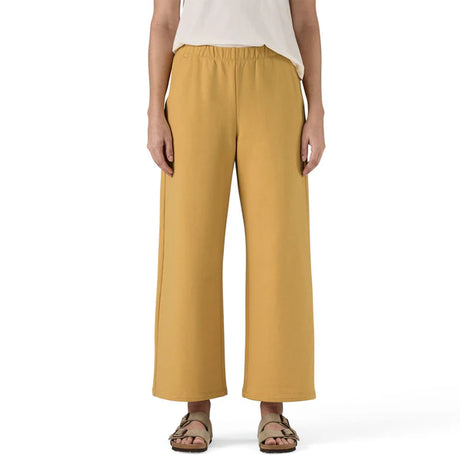 Mustard yellow pants worn by a person on a white background