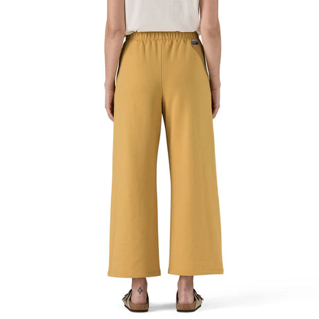 Mustard yellow pants worn by a person on a white background