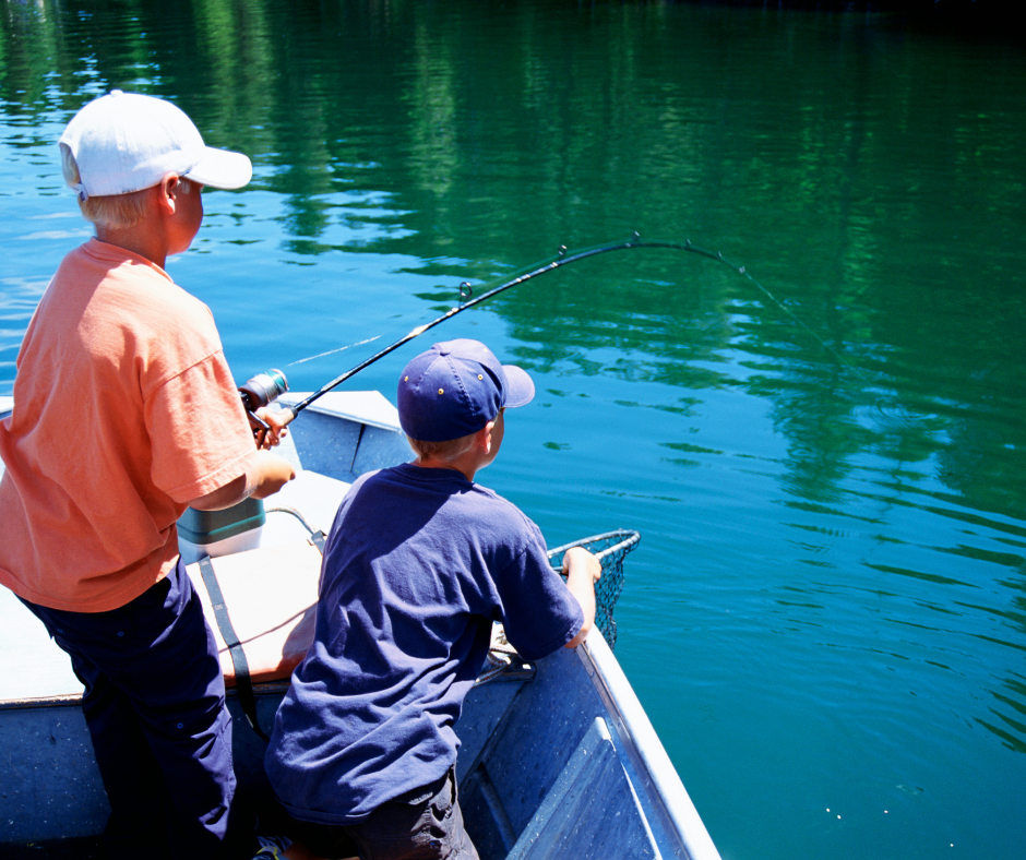 Two boys fishing on a boat.