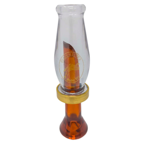 Glass duck call with gold and brown design on a white background