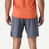 Person wearing gray athletic shorts with a black stripe on a white background