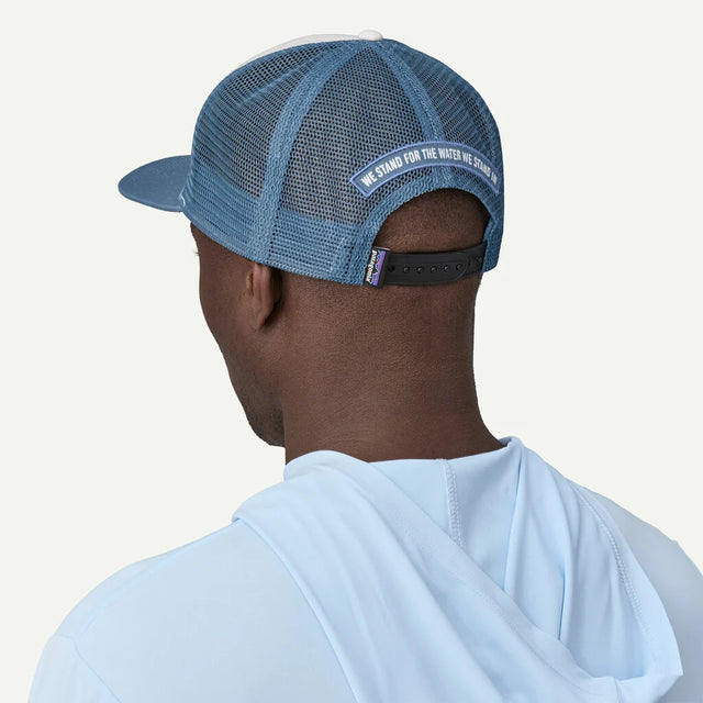 Person wearing a blue mesh cap with text on the back against a white background