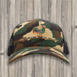 Camouflage baseball cap with a graphic design on a wooden background