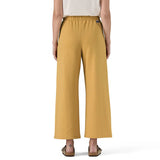 Mustard yellow pants worn by a person on a white background